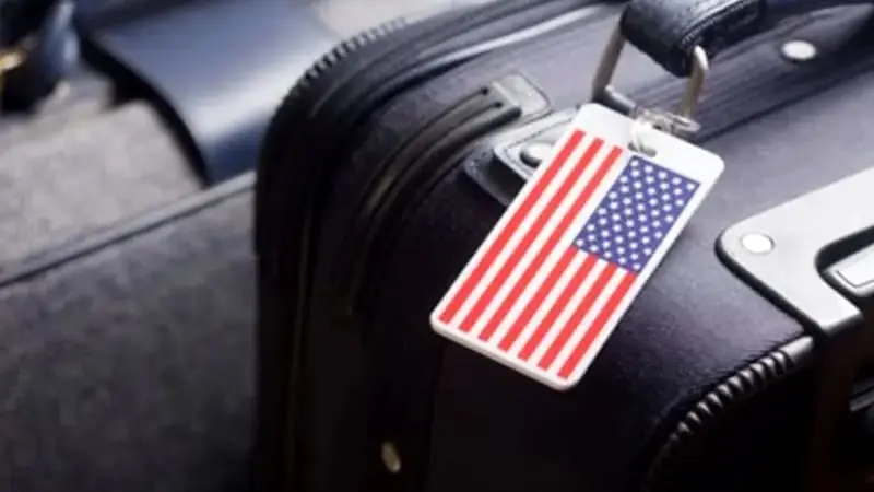 A black suitcase with a luggage tag at airport