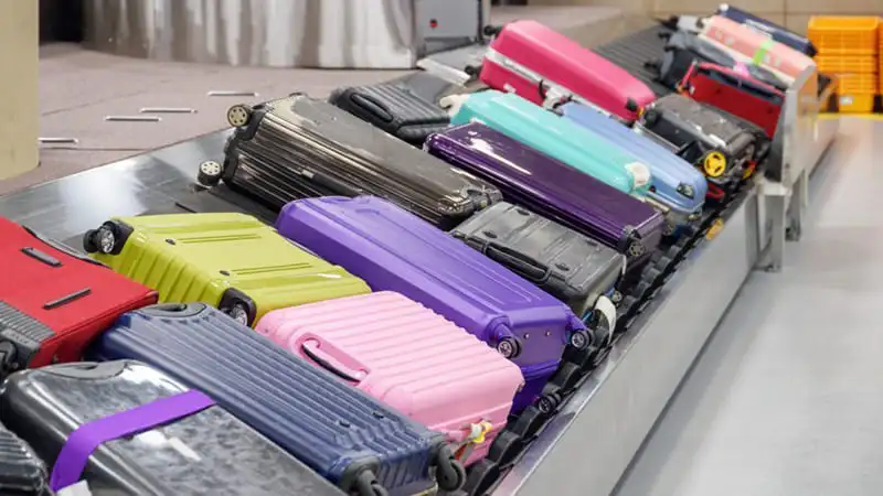 Different color luggage at luggage conveyor at the airport, A place to claim luggage