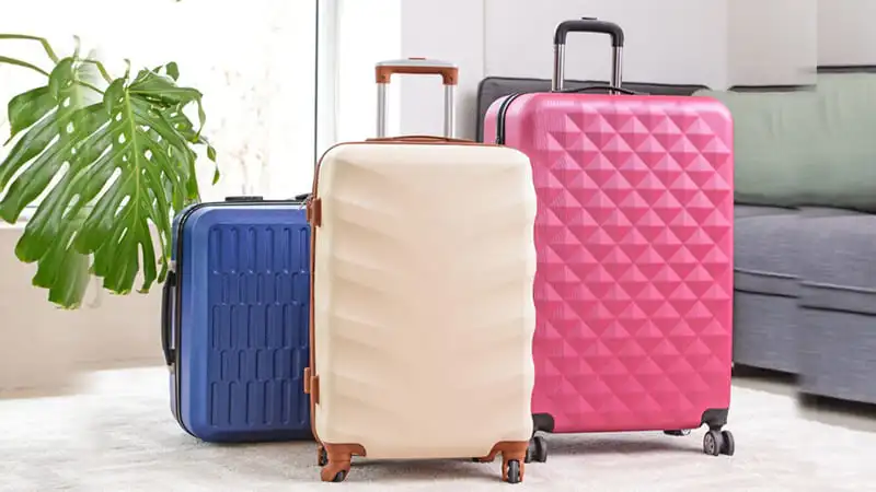 A collection of luggage that are less likely to be stolen. Light Red, light brown and light blue luggage colors